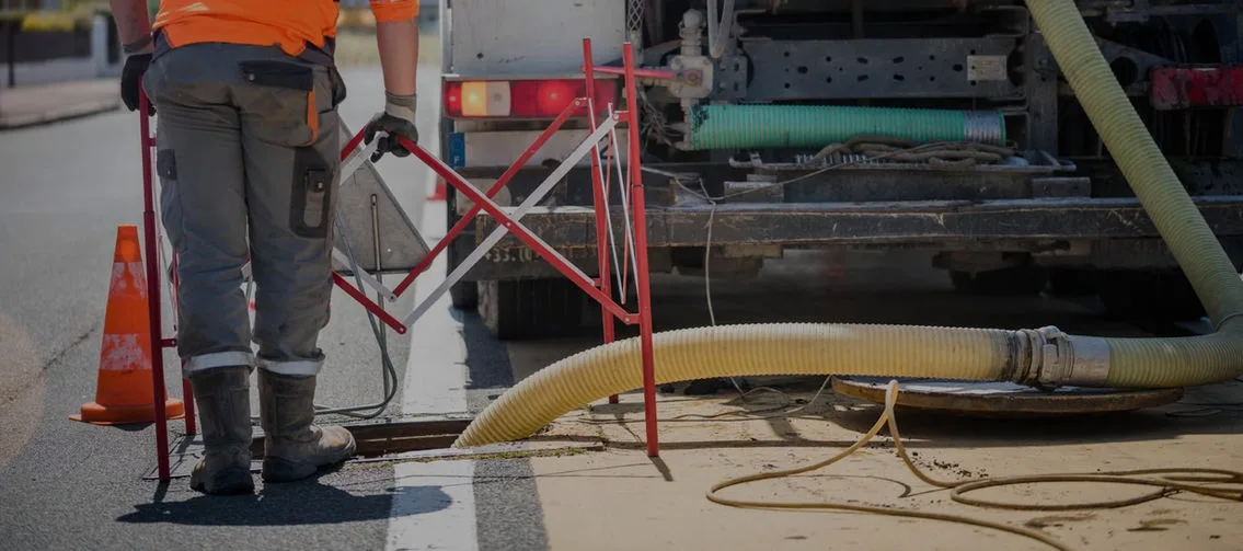 Crew flushing a roadside catch basin from a vacuum truck