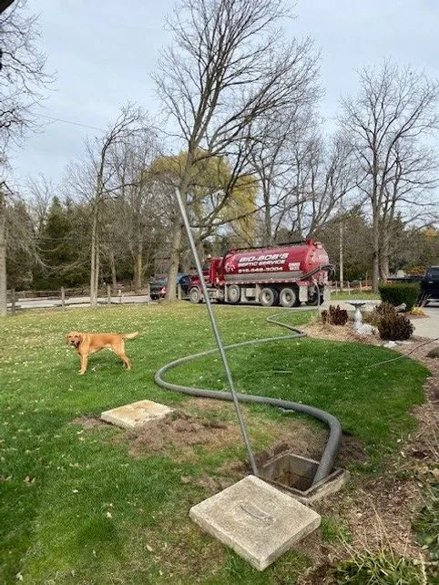Bio-Bob's tanker at a home with the hose run to an open septic tank
