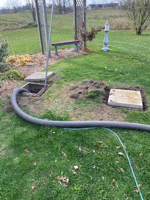 Septic tank access lids opened in a backyard for a pump-out